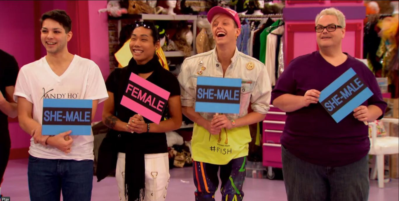 Image: RuPaul's Drag Race, Season 6 Episode 4 screenshot of four of the reality show's contestants holding up signs saying 'She-Male' and 'He-Male' for a show segment RuPaul introduced